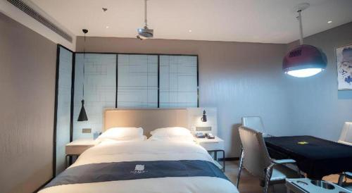 a bedroom with a large bed and a desk in it at Echarm Hotel Changsha Wuyi Square Xiangya Affiliated 1st Provincial Maternity and Child in Changsha