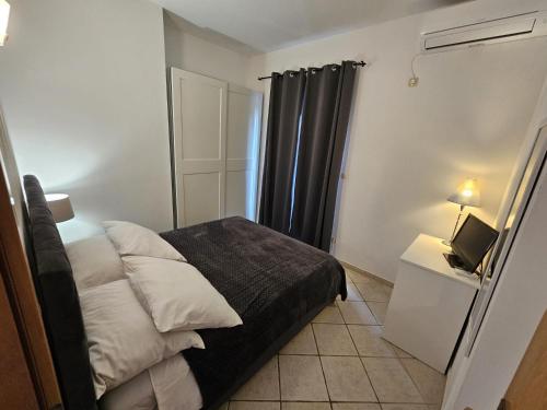 a small bedroom with a bed and a television at Apartmani Katja in Omiš
