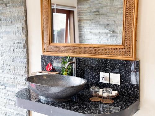 Un baño con un lavabo y un espejo. en Pondok kuwera, en Ubud