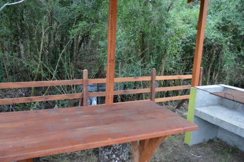 eine Holzbank neben einem Zaun in der Unterkunft Cabañas Valle del Río in Curacautín