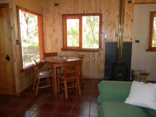 a living room with a table and a couch at Cabañas Valle del Río in Curacautín