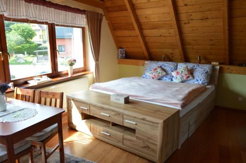 a bedroom with a bed with a desk and a table at Apartmán Monty in Žulová