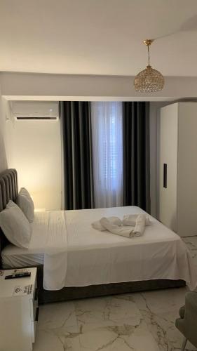 a bedroom with a large white bed in front of a window at Rozafa Guest Room Center in Shkodër
