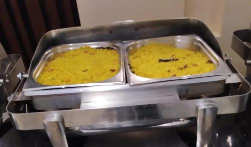 two trays of food being prepared in a machine at Taj Castle by iO Hotels in Amritsar