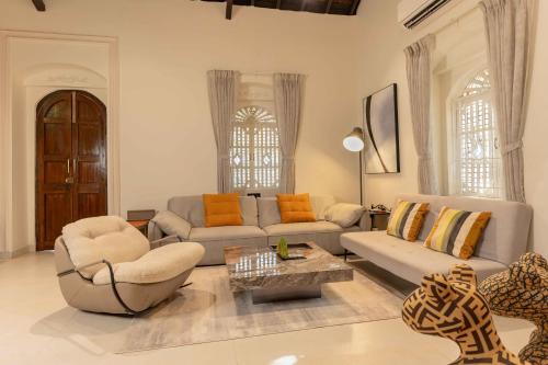 a living room with two couches and a table at Villa Serendipity Aldona in Aldona