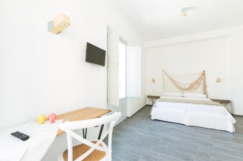 een witte slaapkamer met een bed en een bureau bij Tangram House in Pulsano