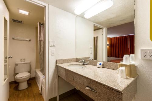 a bathroom with a sink and a toilet and a mirror at Motel 6 Glendale Phoenix in Glendale