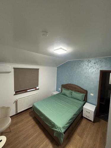 a bedroom with a green bed and a blue wall at Vila La Nașu in Techirghiol