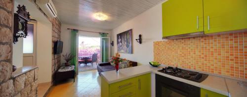 a kitchen with yellow and green cabinets in a room at Apartments Rosso in Hvar