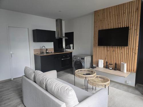 a living room with a couch and two tables at Idéal couples & pro - Patio extérieur- Proche centre ville et gare - Promenade au bord de la Charente - Parking à proximité - Wifi très haut debit - Équipement premium -Netflix in Angoulême