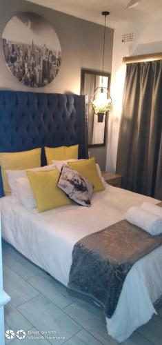a bedroom with a large bed with yellow pillows at Mitchell's Guesthouse in Parow