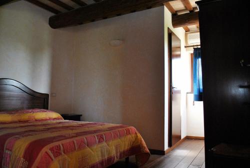 Monte San PietrangeliにあるAgriturismo Oasi Belvedereのベッドルーム1室(カラフルな毛布付きのベッド1台付)