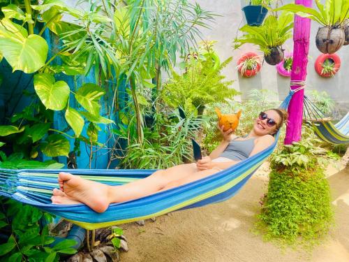 a woman laying in a hammock with a cell phone at Hema Holiday Villa in Trincomalee
