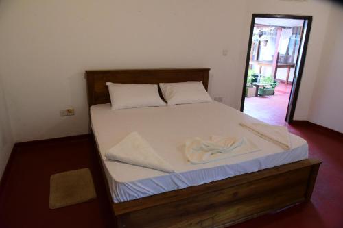 a bed with white sheets and pillows in a room at Mango Breeze Hikkaduwa in Gonapinuwala West