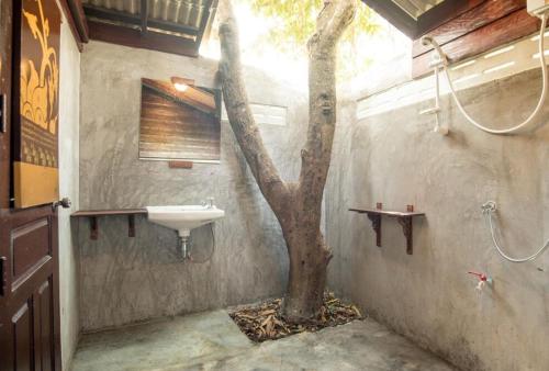 a bathroom with a sink and a tree in it at Boon Homestay & Cafe บุญโฮมสเตย์ in Ban Buak Khang