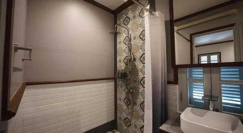 a bathroom with a toilet and a shower with a window at My BanLao Hotel in Luang Prabang