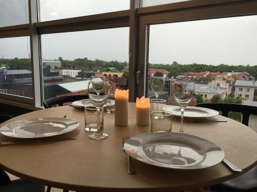 une table en bois avec des assiettes, des verres et une bougie dans l'établissement City View Apartment, free parking, à Pärnu