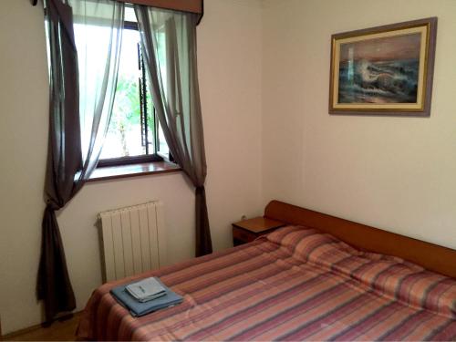 sypialnia z łóżkiem i oknem w obiekcie Villa Plavo More w mieście Novigrad