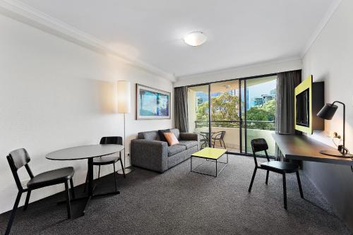 a living room with a couch and a table and chairs at 1 Valentine Ave in Sydney