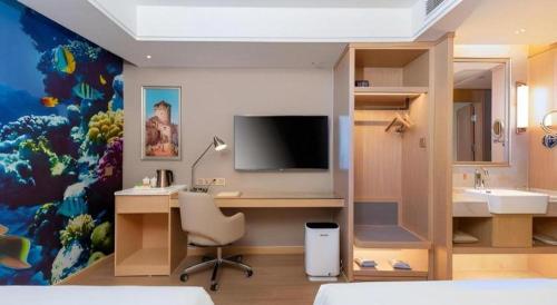 a room with a desk with a television and a sink at Vienna Hotel Tianjin Olympic Sports Center Tianta in Tianjin