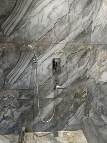 a shower in a bathroom with a marble wall at Taj Castle by iO Hotels in Amritsar