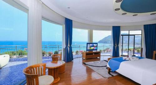 a bedroom with a bed and a view of the ocean at Sanya Luyi Sea View Hotel in Sanya