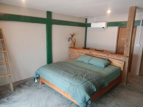 a bedroom with a bed with a cross on the wall at Don Falang Homestay- Private Island in Don Det