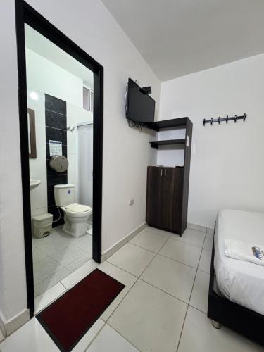 Un dormitorio con una cama y un baño con espejo. en Hotel Gixael, en Santa Marta