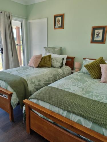two beds sitting next to each other in a room at Cottonvale Country Lodge 