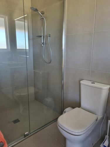 a bathroom with a toilet and a glass shower at Cottonvale Country Lodge 