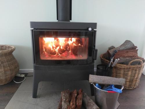 a black stove with a fire in a room at Cottonvale Country Lodge 