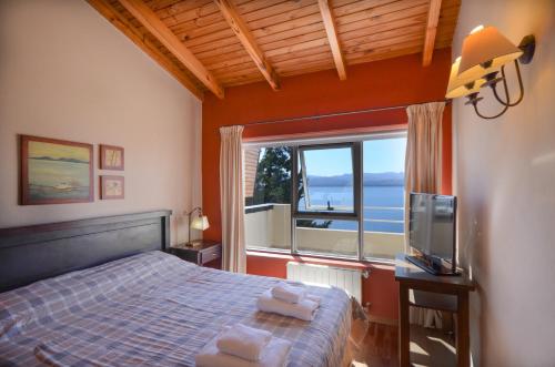 ein Schlafzimmer mit einem Bett und einem großen Fenster in der Unterkunft Balcones al Nahuel in San Carlos de Bariloche