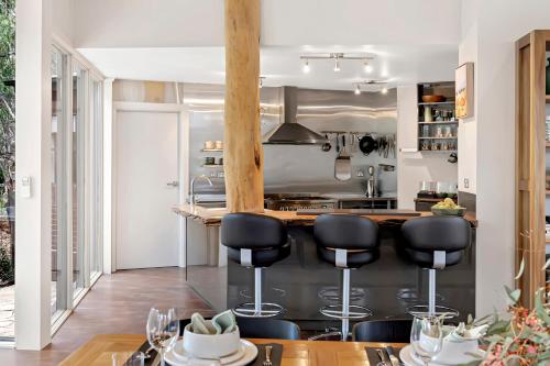 a kitchen with black bar stools and a counter at The Treehouse in Moama