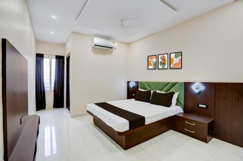 a bedroom with a large bed in a room at Hotel O The Prism rooms and banquet in Patna