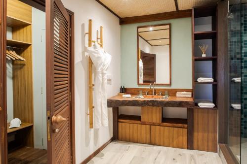 a bathroom with a sink and a mirror at Zebra Moon by muse villas in Cap Malheureux