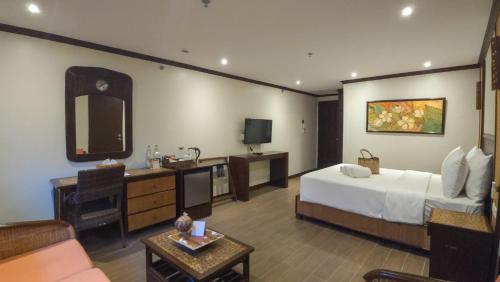 a hotel room with a bed and a television at Red Coconut Beach Hotel Boracay in Boracay