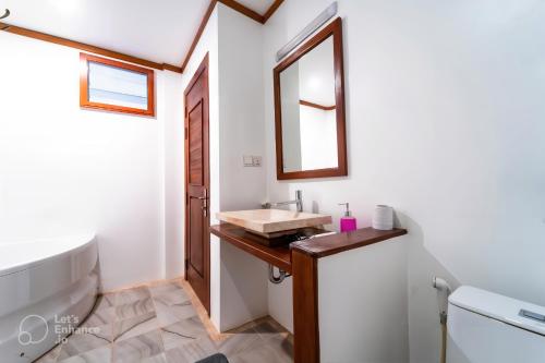 a bathroom with a sink and a mirror at Banksy's Siem Reap in Phumĭ Réach Born