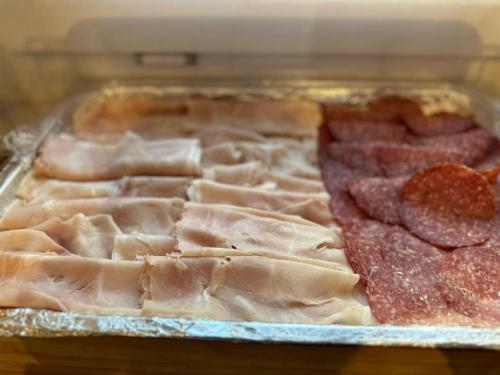 a display case with ham and other meats at Hotel Ravello Adults Only in Rimini