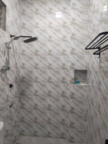 Un baño con ducha con pared de piedra. en Superior Family Room, en Pantai Cenang