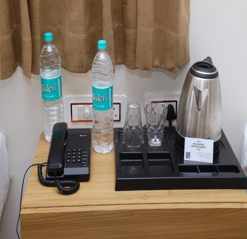 a table with two bottles of water and a telephone at Sri Adhilakshmi Templeview Residency in Tiruvannāmalai