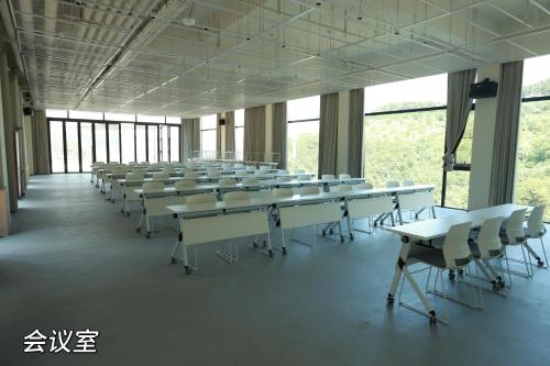 a room with rows of tables and white chairs at Yunjie Qingsongling Study Resort in Changzhi