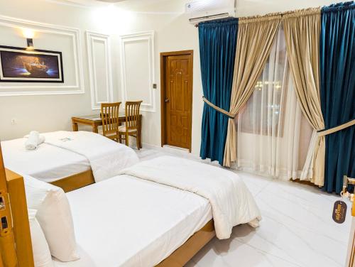 a hotel room with two beds and a window at Hotel StayInn - Airport Branch Karachi in Karachi