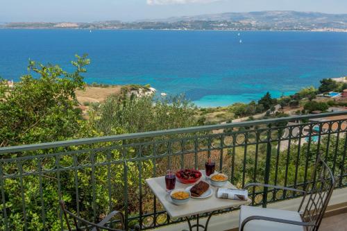 a table with food on a balcony with a view of the ocean at Ionian Vista Villas in Argostoli