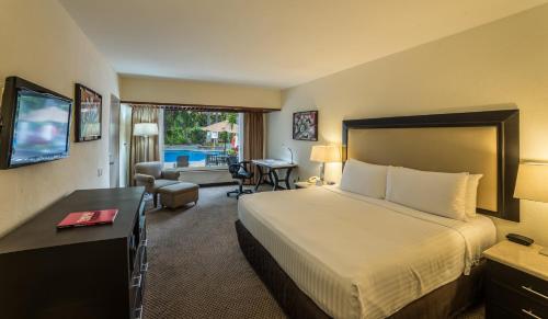 a hotel room with a bed and a living room at Holiday Inn Guadalajara Expo Plaza del Sol, an IHG Hotel in Guadalajara