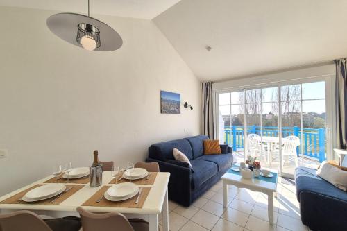 un salon avec un canapé bleu et une table dans l'établissement Nice apartment with balcony - Les rêves Bleus, à Saint-Hilaire-de-Talmont