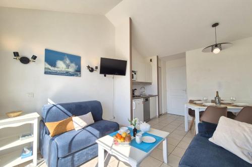 un salon avec un canapé bleu et une table dans l'établissement Nice apartment with balcony - Les rêves Bleus, à Saint-Hilaire-de-Talmont