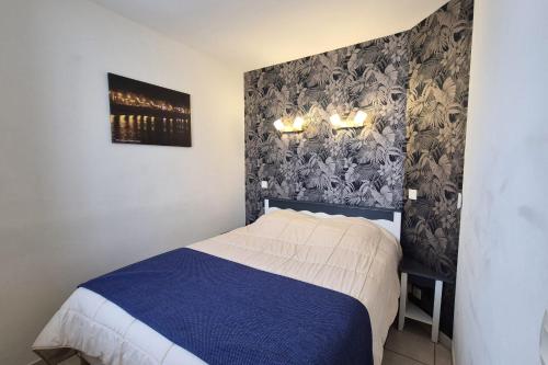 une chambre avec un lit avec une couverture bleue et blanche dans l'établissement Nice apartment with balcony - Les rêves Bleus, à Saint-Hilaire-de-Talmont