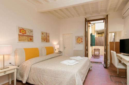 Dormitorio con cama, escritorio y TV en Pinocchio House, en Florencia