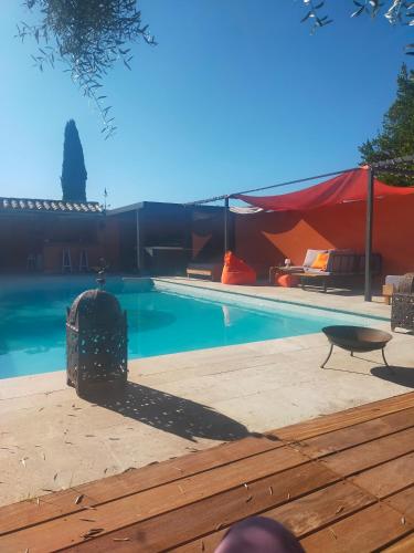 une piscine avec une tente rouge à côté dans l'établissement L'Amuse-Bouche, à Tresques