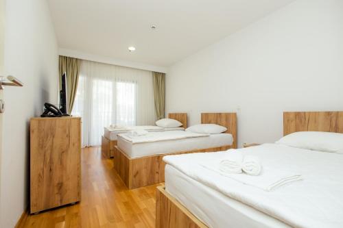 a hotel room with three beds and a television at Hotel PIO in Ulcinj